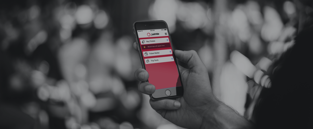 the JustRide mobile ticketing app being held up by a hand