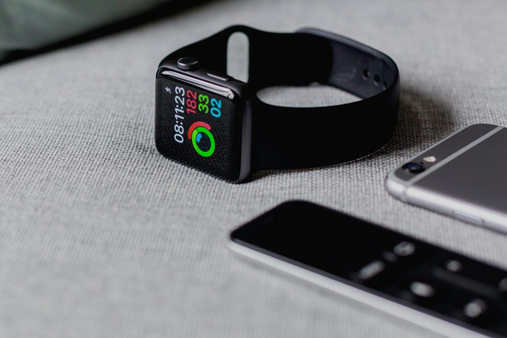 Apple Watch on a work surface next to other devices