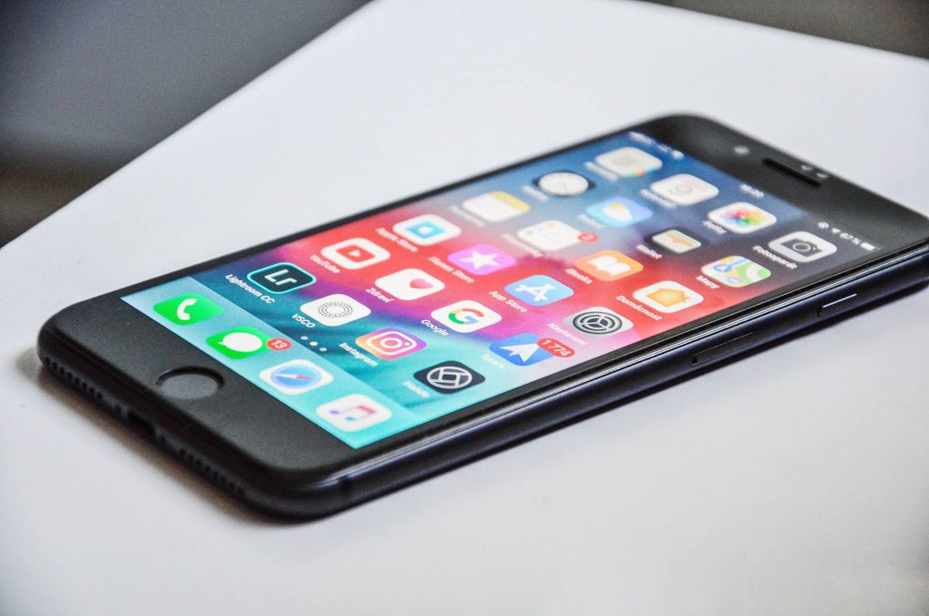 iPhone on a table showing home screen icons