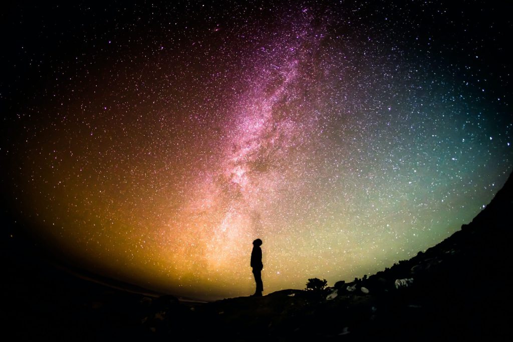 Silhouette of a person looking up into the sky at night.