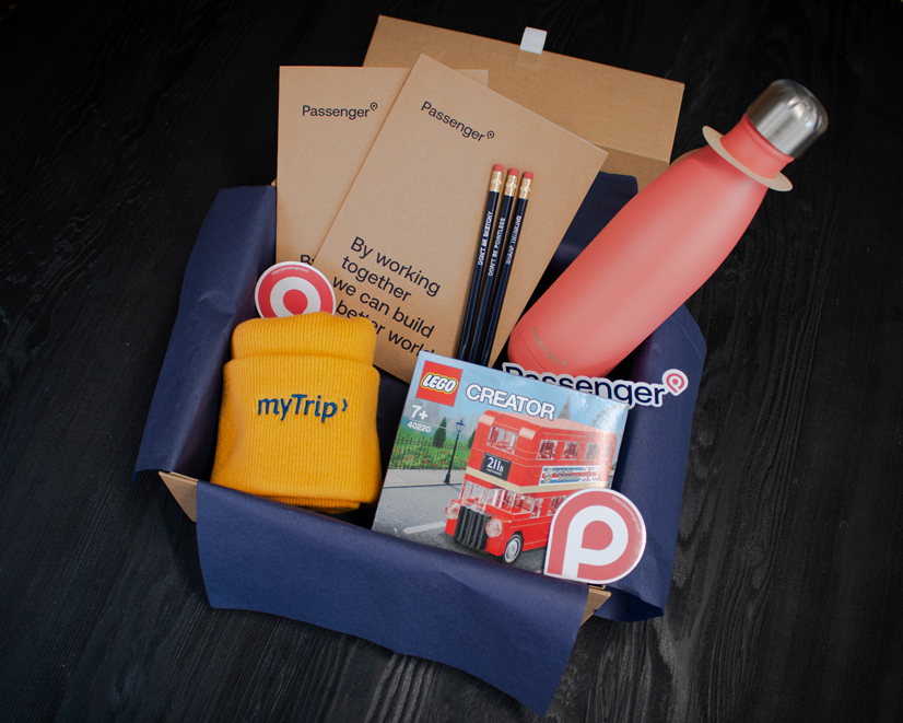 A box containing notebook, pencils, resuable waterbottle, a lego set of a London bus and stickers.