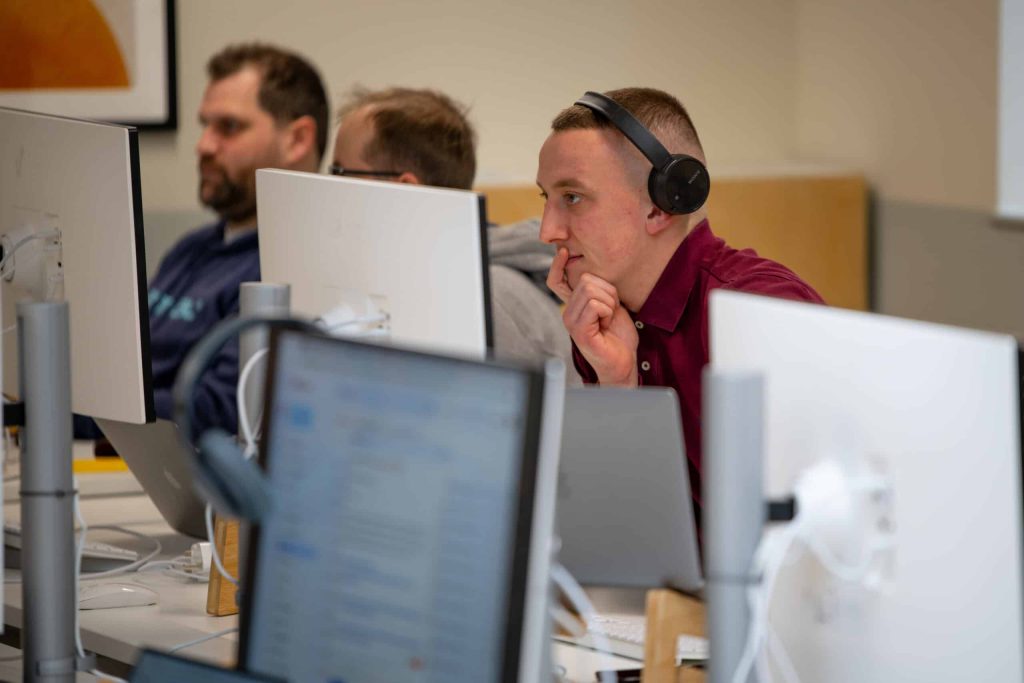3 people working at desks in an office